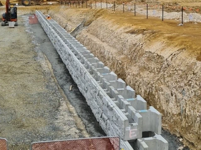 Long MagnumStone retaining wall with gravity extenders behind standard units