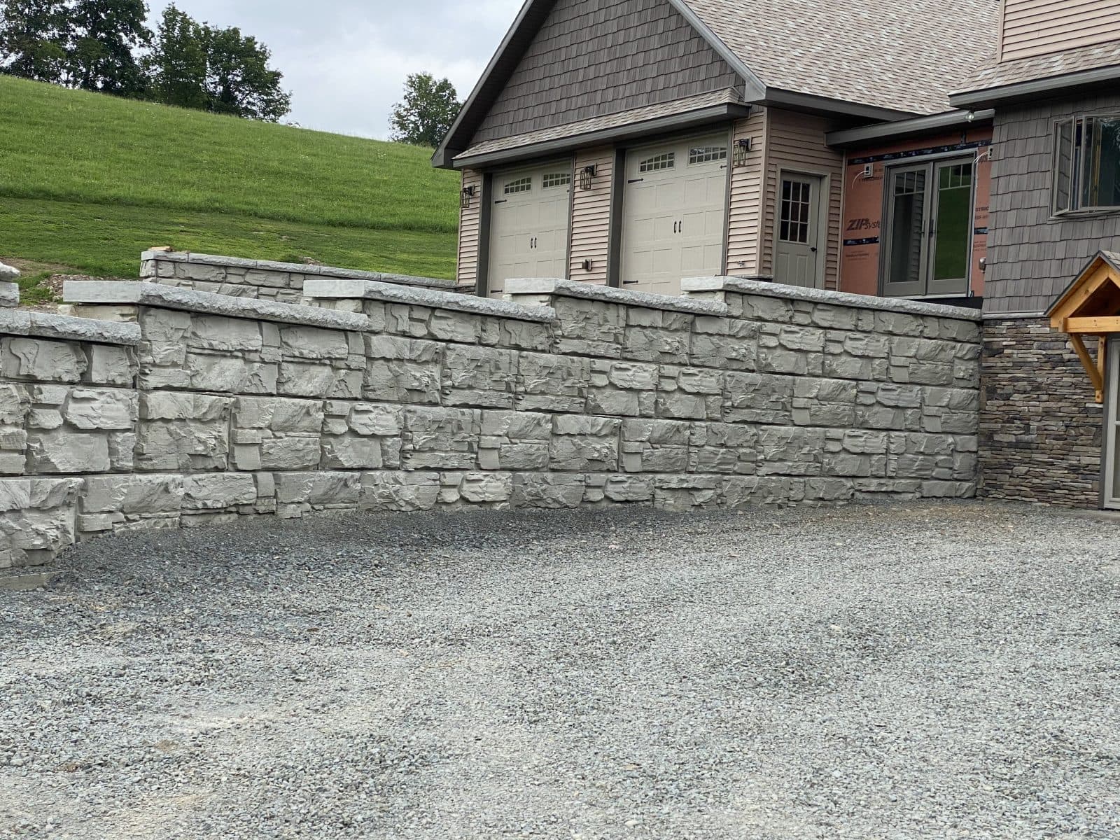 MagnumStone Retaining Wall used to extend a driveway. It features a step-up wall leading up to the home.
