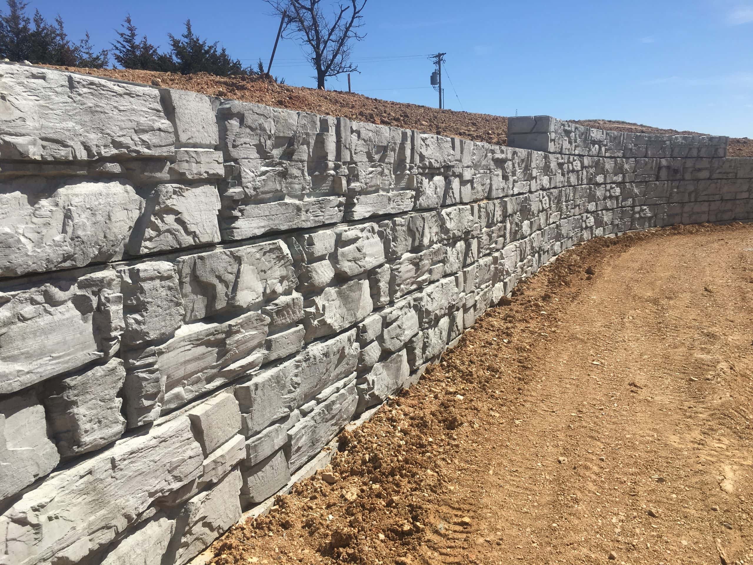 Freshly installed MagnumStone retaining wall with concave curve.