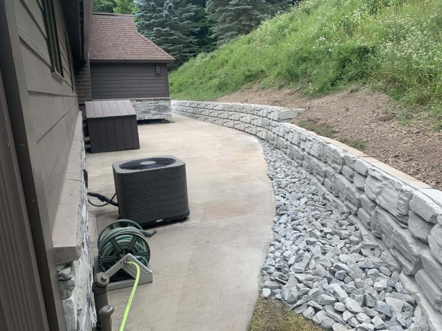 Backyard retaining wall built with only half-high blocks due to tight space.