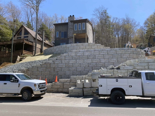 MagnumStone hybrid gravity and geogrid retaining walls for residential house.