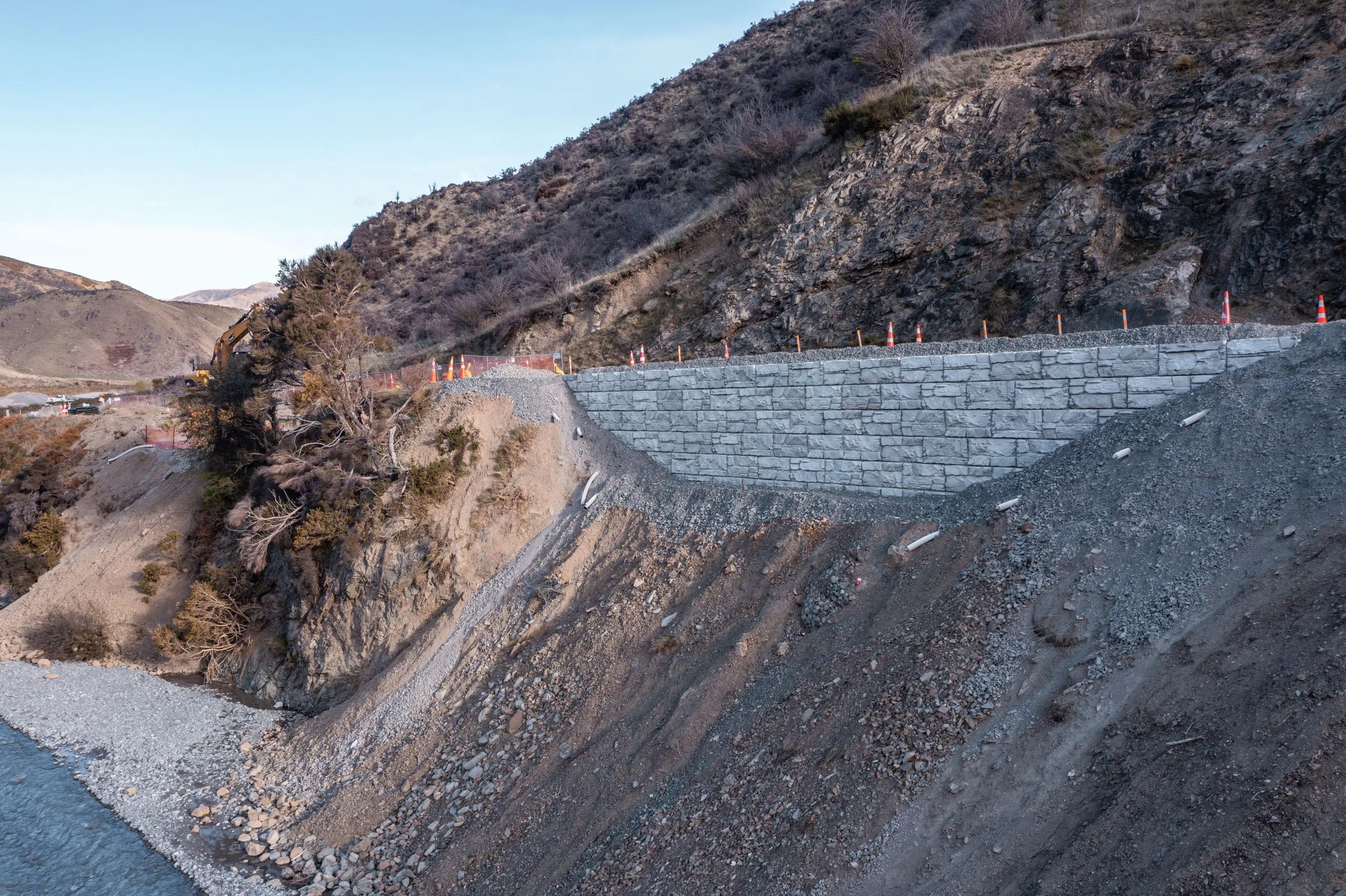 Big Block retaining wall fixes roadway above landslide.