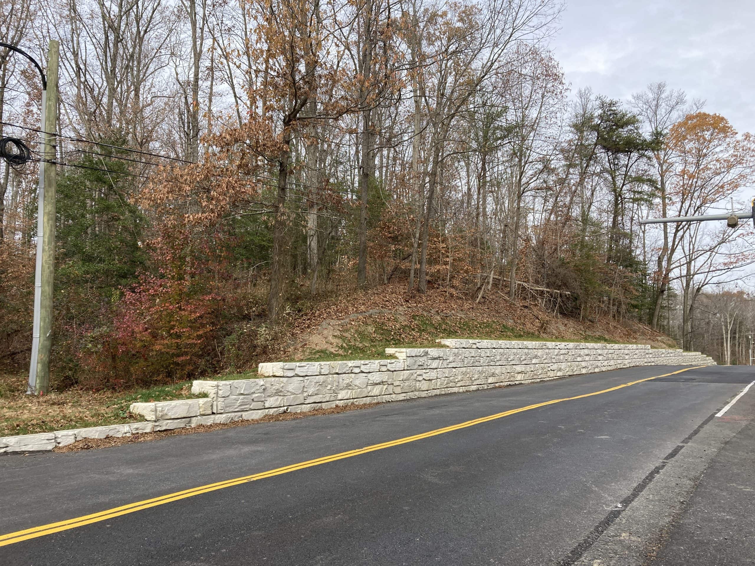 Retaining wall protects roadway with MagnumStone blocks.