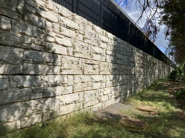 Tall MagnumStone textured block retaining wall.