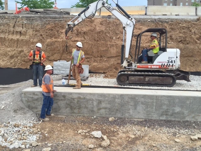 Installing Base Course of St. Louis Metro Railway Block Wall.