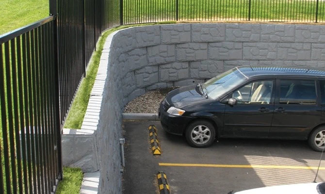 MagnumStone curved retaining wall with fence built in.