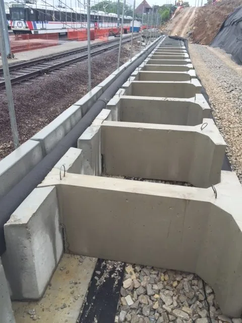 MagnumStone multi-length gravity extenders for railway retaining wall.