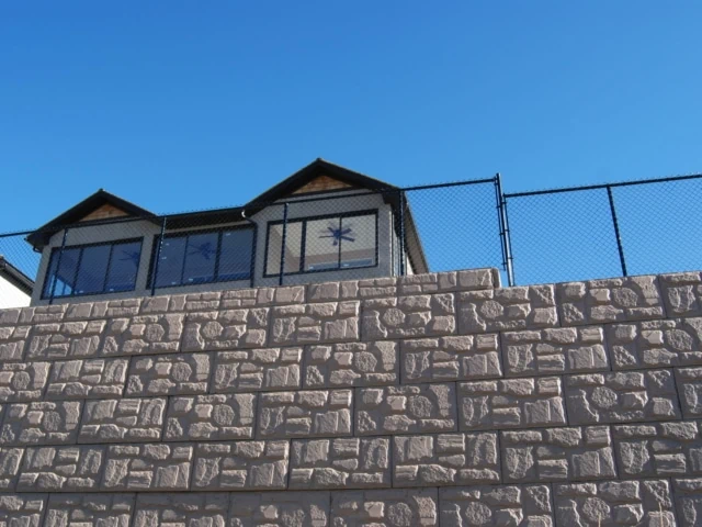 Tall MagnumStone wall with built-in fence.