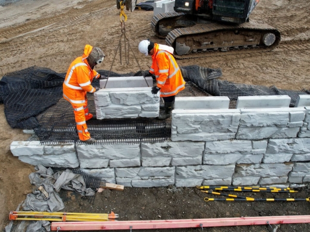 Positioning MagnumStone block on retaining wall.